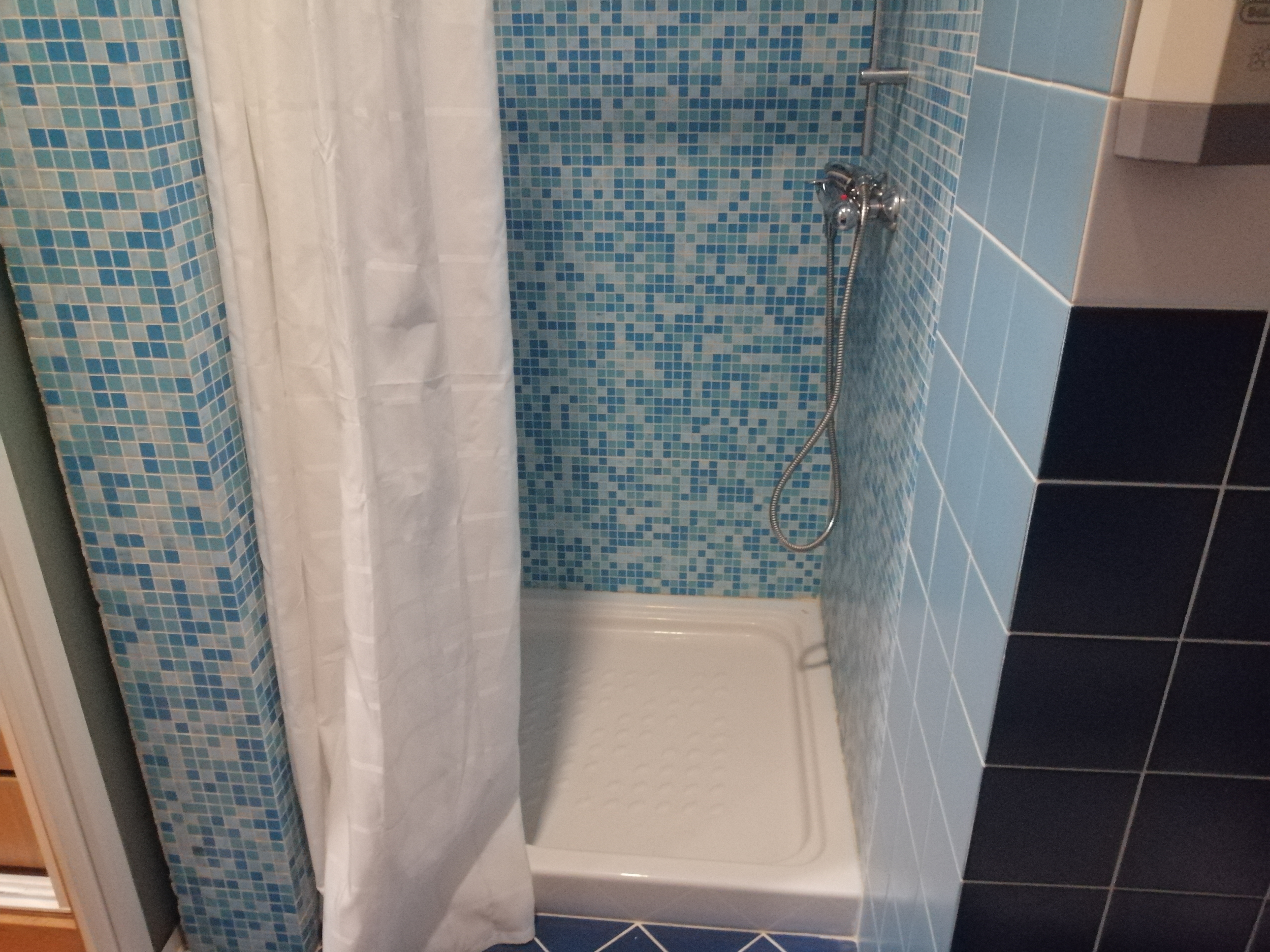 Casa de banho privativa da suite com base de duche e mosaico azul